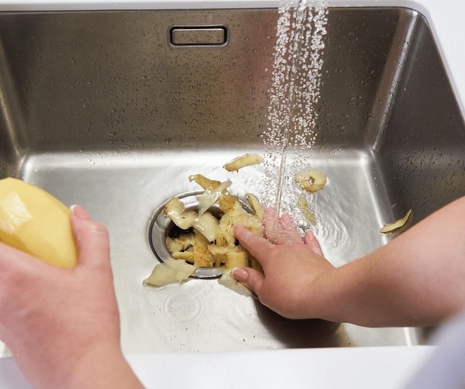 The sink is stainless steel, with a stream of water running.