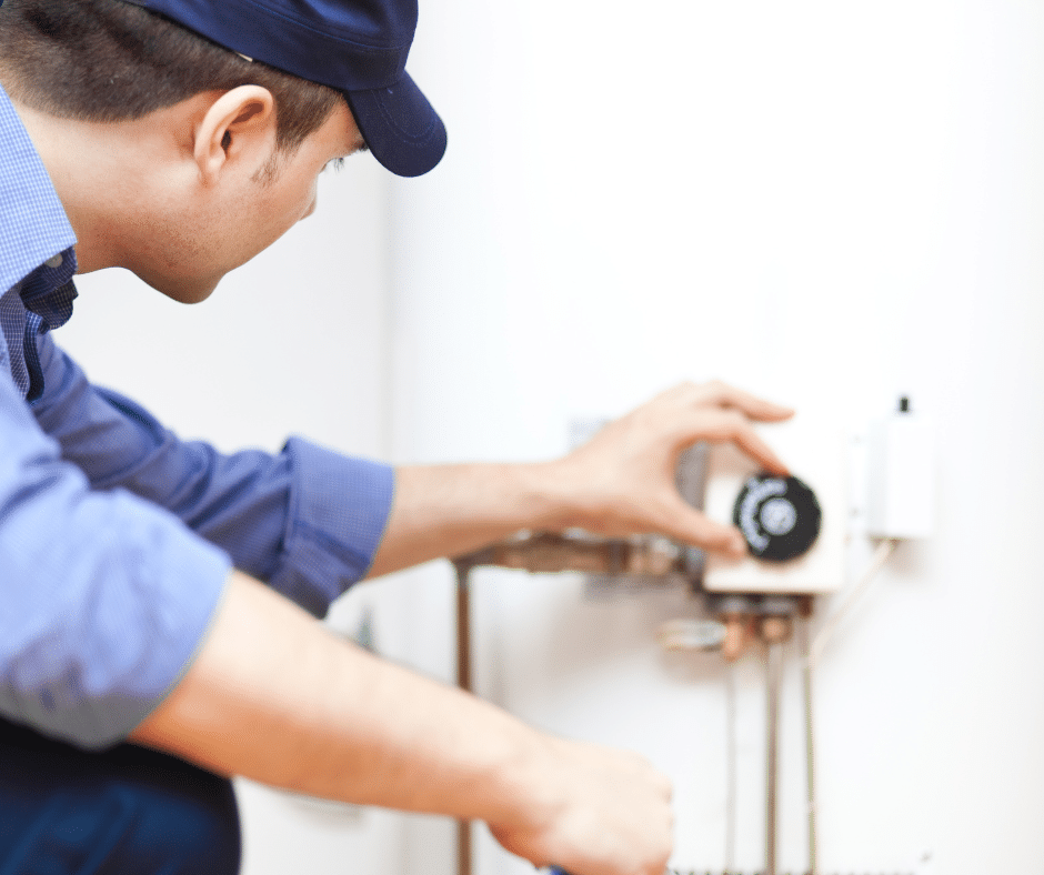 A technician adjusts the temperature on a tankless water heater